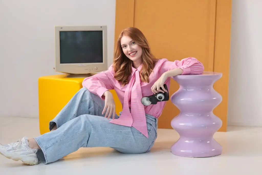 Jonge vrouw liggend op kleurrijke poefjes in een speelse studio-opstelling met pastelkleuren. Daglicht Studio in Nederland Brabant